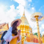 A young woman praying at Wat Phra That Doi Suthep, a famous tourist attraction and places of interest in Chiang Mai, Thailand