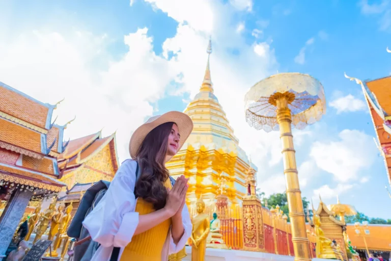 A young woman praying at Wat Phra That Doi Suthep, a famous tourist attraction and places of interest in Chiang Mai, Thailand