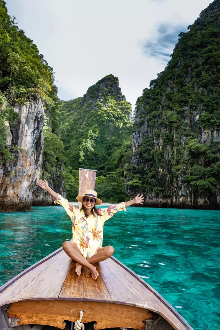 Maya Bay Koh Phi Phi Thailand, Turquoise clear water Thailand Koh Pi Pi, Scenic aerial view of Koh Phi Phi Island in Thailand. Asian woman mid age with hat in longtail boat