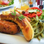 Fish espada with fried banana, french potatoes, kidney beans and fresh vegetables