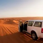 Off-road vehicle in the wahiba sands desert dunes at sunset (Oman)