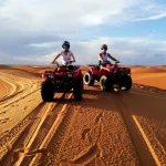 Couple driving quads in the sahara desert